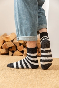 Détail de chaussettes en polaire corail à rayures noires et blanches pour un hiver chaud