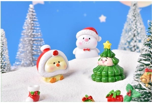 Miniature Christmas resin figurines with snowman and festive duck on artificial snow