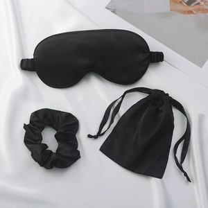 Three-piece black faux silk sleep set including eye mask, scrunchie and drawstring bag