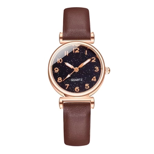 Detail of rose gold case with black starry dial and Arabic numerals on quartz watch