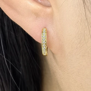 Macro shot of gold S925 sterling silver hoop earrings with pave-set shimmering crystals