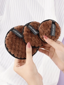 Detailed view of three brown microfiber makeup sponges with black ribbon handles