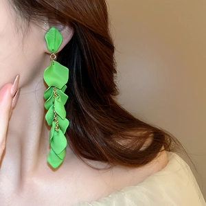 Close-up of elegant green rose petal tassel clip-on earrings worn by a model