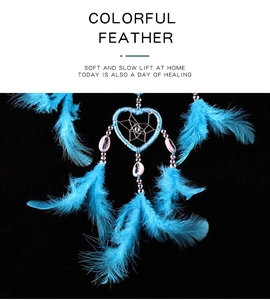 Detailed view of heart-shaped dream catcher with blue feathers and delicate bead strings