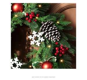 Detail of 40cm Christmas wreath with red berries and warm LED lights on a wooden door