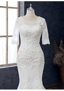 Detail eines Meerjungfrau-Brautkleids mit Spitzenapplikationen und Pailletten