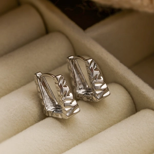Minimalist silver geometric earrings with irregular faceted texture in a velvet box
