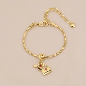 Detailed shot of golden charm bracelet with high heel, lipstick and shopping bag charms