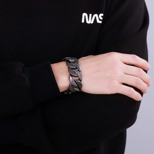 Détail d'un bracelet gourmette épais en acier inoxydable de couleur bronze