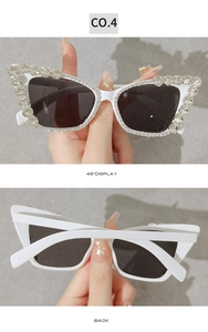 Detailed view of white cat-eye sunglasses with rhinestone chains and dark lenses