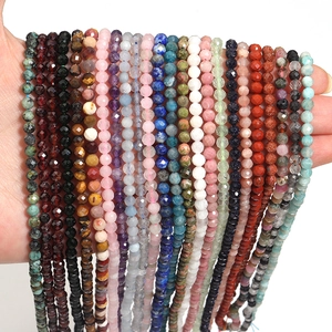 Detailed close-up of faceted natural gemstone beads held by hand for DIY jewelry making