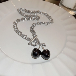 Detail of silver chain necklace with black cherry pendant and stylish toggle clasp