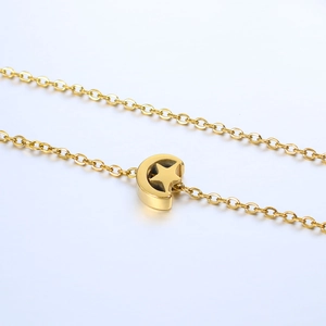 Detail of gold moon and star pendant with polished O-chain on white background