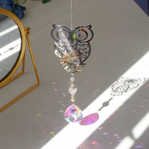Detailed view of metal owl suncatcher with crystal ball prism reflecting rainbows