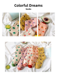 Detail view of five pairs of cotton socks featuring embroidered fruit and vegetable patterns