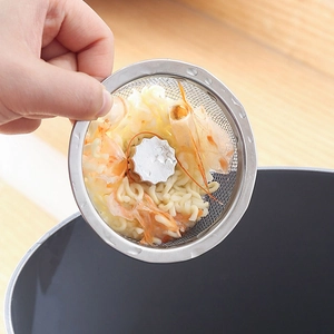 Stainless steel sink strainer with metal mesh filtering food waste in kitchen sink