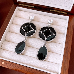 Close-up of vintage black teardrop earrings with crystals on a jewelry box liner