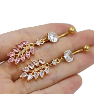 Detailed view of pink and white teardrop zircon belly rings in gold metal setting