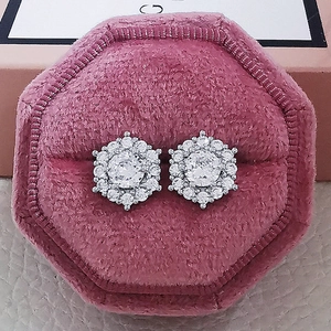 Macro shot of sparkling snowflake stud earrings with crystals in a pink velvet box