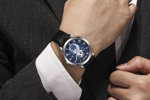 Close-up of men's blue starry dial watch with earth pattern and black leather strap