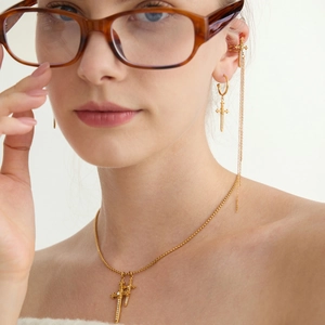 Golden sword cross jewelry set with necklace and tassel cuff earring on female model