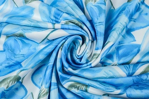 Macro detail of blue floral print on white fabric showing soft silky twill texture
