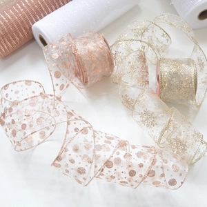 Detail of rose gold champagne chiffon ribbon with sequin dots and snowflake patterns