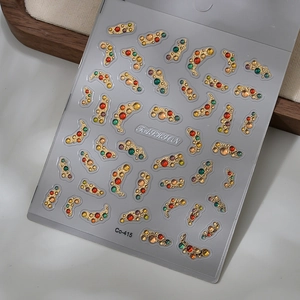 Detailed macro view of 3D nail art stickers with vintage jewels and gold embossed textures