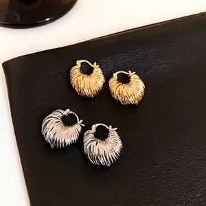 U-shaped metal hoop earrings in gold and silver finish with vertical ribbed texture