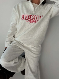 Detailed view of grey embroidered half-zip sweatshirt and matching sweatpants set
