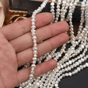 Natural white baroque freshwater pearls for DIY jewelry making held in hand for scale