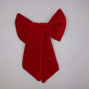 Detail view of a large red velvet decorative butterfly bow with soft plush texture
