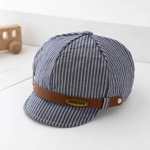 Close-up of blue striped baby sun hat with brown leather strap and metal emblem