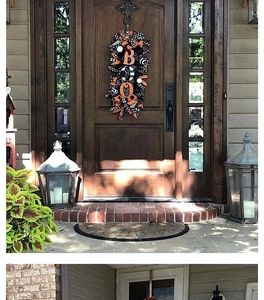 Detailed porch view of a festive Halloween wreath with orange bows and BOO letters