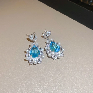 Elegant silver earrings with large pear-cut blue gemstone and white pearl accents