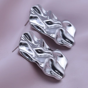 Close-up of irregular pleated 304 stainless steel earrings with liquid metal texture