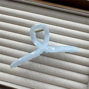 Detail of light blue marble acetate hair claw clip with golden spring and cloud pattern