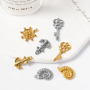 Macro view of nautical charms including anchors and rudders on a white tray