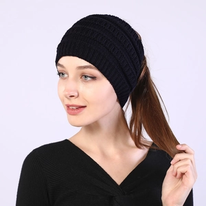 Close-up of black knitted headband with open top design for ponytails on model