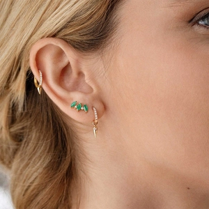 Detail of S925 silver gold-plated hoop earrings with spikes and green zircon stud