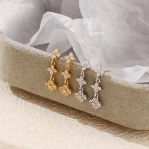 Detail showing s925 silver four-leaf clover zircon earrings in gold and silver finish