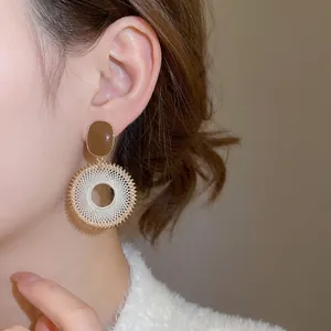 Bohemian woven hoop earrings with brown resin and intricate white mesh pattern