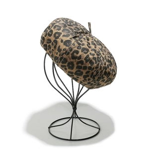 Classic leopard print beret hat for women displayed on a black metal stand with white background