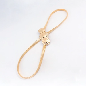 Detail of gold elastic metal belt with three round seashell-shaped decorative buckles