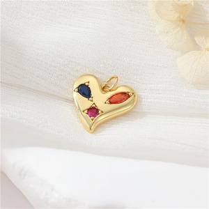 Macro shot of gold heart pendant with colorful blue red and pink zircon gemstones