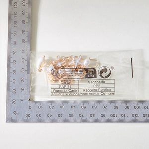 Macro detail of starfish and shell earrings measured with a ruler for size reference