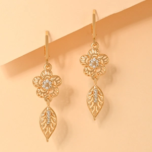 Close-up of champagne gold hollow floral earrings with sparkling white cubic zirconia
