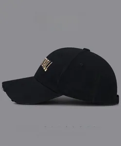 Close-up of black cotton baseball cap with gold embroidery and stylish distressed brim