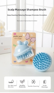 Close-up of light blue silicone scalp massage brush with tapered bristles in packaging
