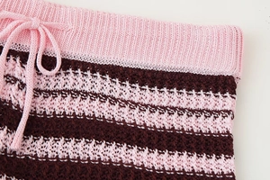 Close-up of pink and brown striped knit fabric with drawstring and ribbed waistband